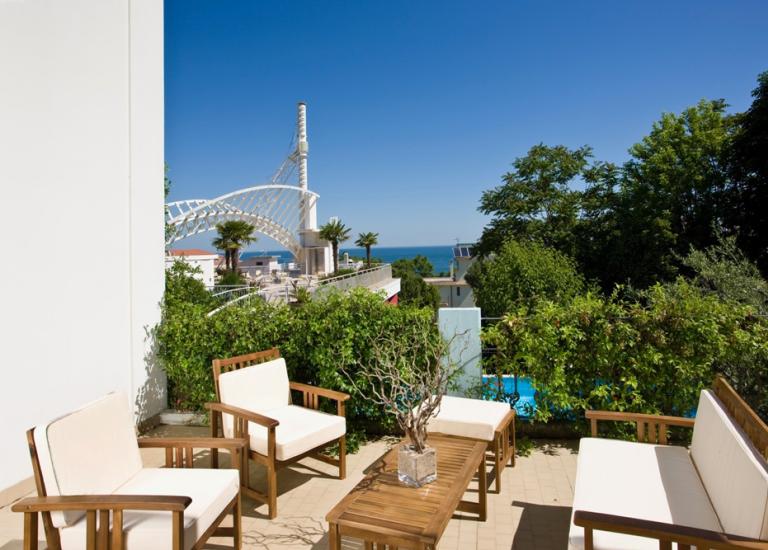 Terrazza con mobili da esterno e vista sul mare.