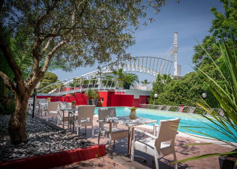 Terrazza con mobili in legno, vista piscina e giardino.